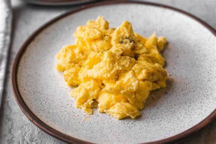 What makes scrambled eggs fluffy water or milk?